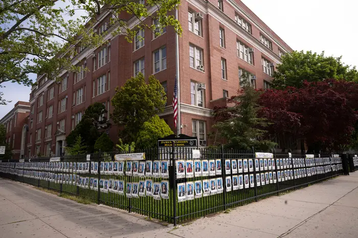 Photographs of the graduating class of 2020 line the fence in front of James Madison High School, in the Brooklyn borough of New York. The portraits honor the 750 graduating seniors who may not have the opportunity to step across a graduation stage this year due to the coronavirus pandemic